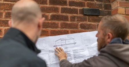 A Building Inspector and Builder Reviewing a Plan